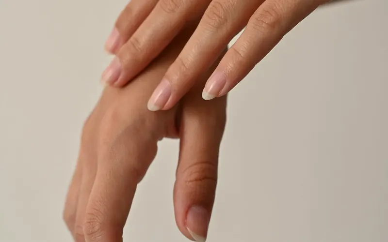 Mão em primeiro plano, com as unhas em foco